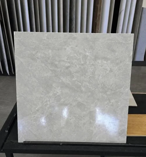 Amostra de porcelanato cinza claro marmorizado com superfície brilhante que reflete a luz