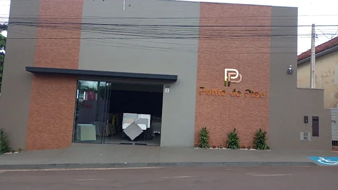 Fachada da Ponto do Piso, com painel em tijolinho e letreiro dourado