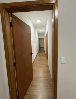 Corredor com piso em réguas amadeiradas.