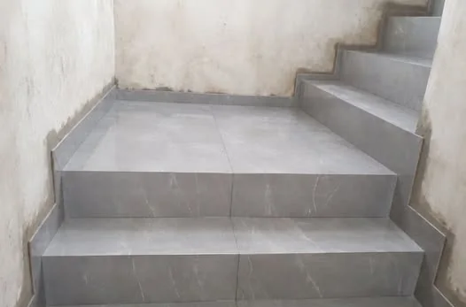 Patamar e degraus em porcelanato cinza claro, com acabamento nas laterais.