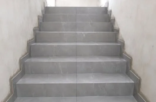 Lance completo de escada com degraus em porcelanato cinza claro.